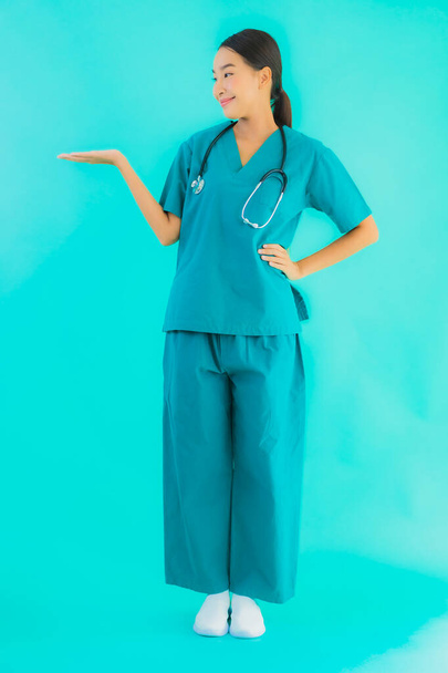 Πορτρέτο όμορφη νεαρή Ασιάτισσα γιατρός γυναίκα χαρούμενο χαμόγελο για την εργασία στο νοσοκομείο και κλινική σε μπλε απομονωμένο φόντο - Φωτογραφία, εικόνα
