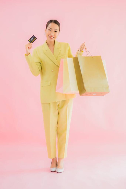 Portré gyönyörű fiatal ázsiai üzletasszony bevásárló táska színes elszigetelt háttér - Fotó, kép