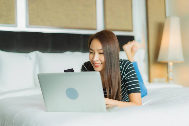 Portré gyönyörű fiatal ázsiai nő használja okos mobiltelefon számítógép laptop és hitelkártya az online vásárlás - Fotó, kép