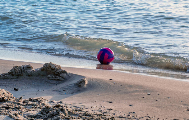 Pallavolo rosa e blu è in pericolo di lavare via, in quanto poggia sulle rive del lago Michigan - Foto, immagini