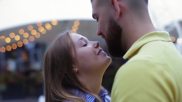 Közelkép a romantikus fiatal pár ölelkező csókolózás dátumon, elmosódott háttér szökőkút étterem kívül este lassított felvételen. Szerető lány és barátja élvezze szabadtéri kikapcsolódás együtt. - Felvétel, videó