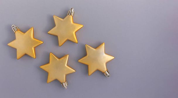 Weihnachten Hintergrund von goldenen Sternen auf einem grauen Hintergrund. Ornament für Weihnachten und Neujahr - Foto, Bild