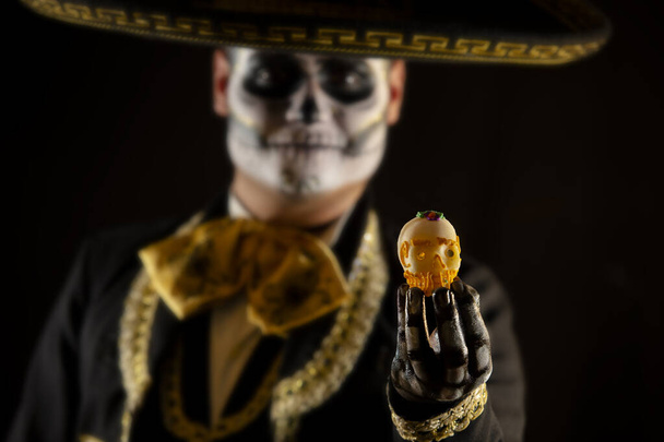 Мексиканский шарро держит в руках леденцовый череп - Фото, изображение