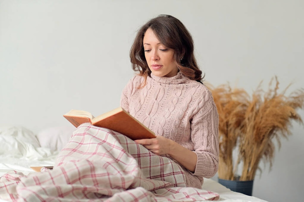 Retrato suave de una hermosa mujer acostada en la cama por la mañana. libro de lectura - Foto, Imagen