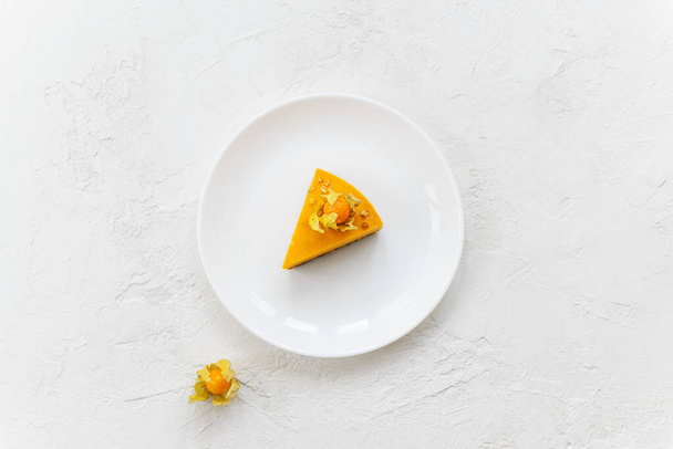 A slice of homemade pumpkin and orange cake on a white table. Horizontal orientation, top view. - Foto, afbeelding