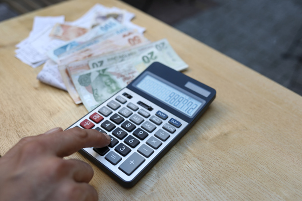 hombre haciendo transacciones financieras con calculadora sosteniendo dinero en han - Foto, Imagen