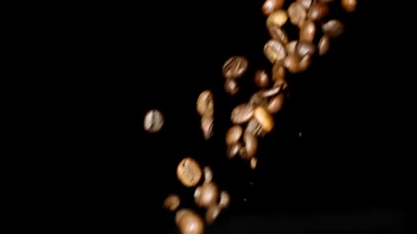 Κόκκοι καφέ ρίχνει κάτω σε αργή κίνηση σε απομονωμένο μαύρο φόντο, αντίγραφο χώρου - Πλάνα, βίντεο