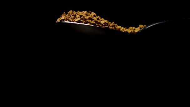 Στιγμιαία κομμάτια καφέ που πέφτουν από κουτάλι σε αργή κίνηση σε μαύρο φόντο - Πλάνα, βίντεο