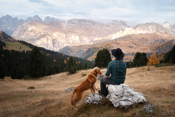 man with a dog in the mountains. travel, hiking with a pet. Nova Scotia Duck Tolling Retriever - Фото, зображення