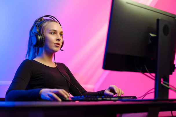 Фокусована дівчина-геймер з гарнітурою Граючи онлайн відеоігри на ПК
 - Фото, зображення