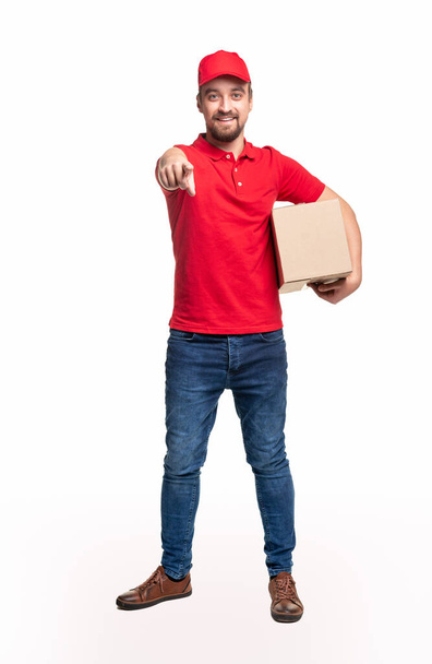 Positive delivery man pointing at camera - Foto, afbeelding