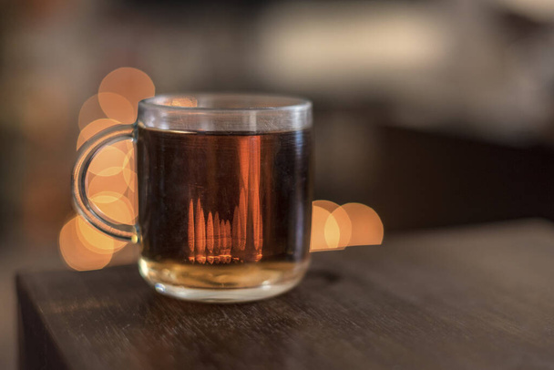 A cup of tea on a wooden table in front of the bokeh effects, close up, isolated - Photo, Image