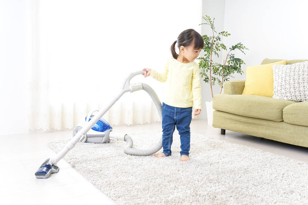 Child cleaning room, little girl with vacuum cleaner - Fotografie, Obrázek