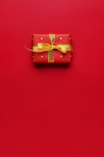 Red Christmas gift on red background with copy space. - Fotoğraf, Görsel