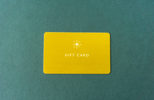 Tarjeta de regalo sobre fondo verde. tarjeta de regalo amarillo. - Foto, imagen