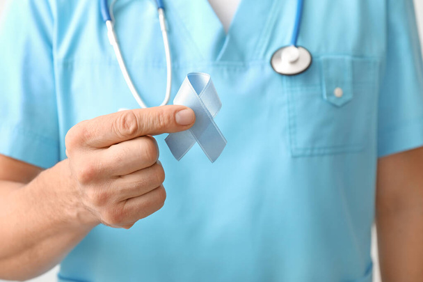 Мужчина-врач с голубой лентой, крупным планом. Концепция информирования о раке предстательной железы - Фото, изображение