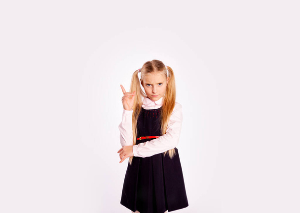 chica en estricto uniforme negro sobre un fondo blanco - Foto, Imagen
