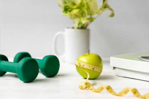 Close up green apple with measuring tape .  Diet Health Plan.  Nutrition start up workout planing. Sport exercise equipment workout gym background. Healthy Lifestyle Concep - Valokuva, kuva