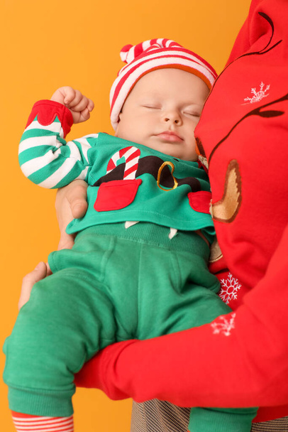Madre con lindo bebé en traje de elfo sobre fondo de color - Foto, imagen