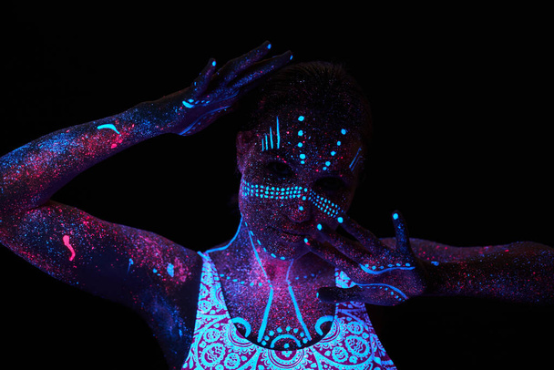 Art woman cosmos in ultraviolet light. Entire body is covered with colored droplets. Girl posing in the dark. Noise, out of focus - Fotó, kép