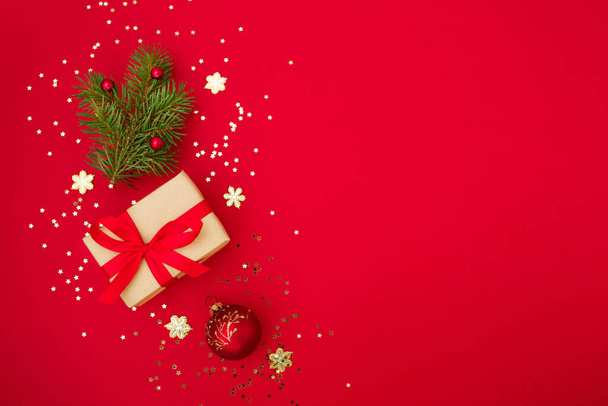 Carte de voeux de composition de Noël. Cadeaux de papier artisanal sur fond rouge avec une étoile d'or confettis et décoration de Noël. Vue de dessus, plan plat - Photo, image