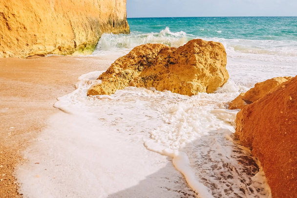 Κύματα συντρίβονται σε βράχους στις αμμώδεις ακτές της παραλίας του Benagil στην Πορτογαλία - Φωτογραφία, εικόνα