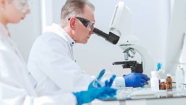 pharmacists from all over using microscope in the laboratory. - Foto, Bild
