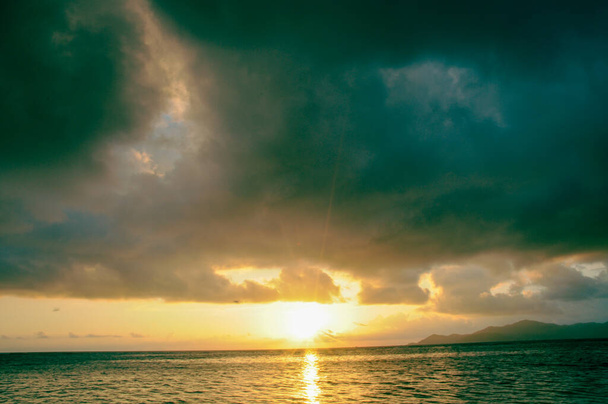 海に沈む夕日の暗い雲 - 写真・画像