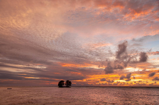 島の黒いシルエットの海の地平線の上に美しい熱帯の夕日。セーシェル - 写真・画像