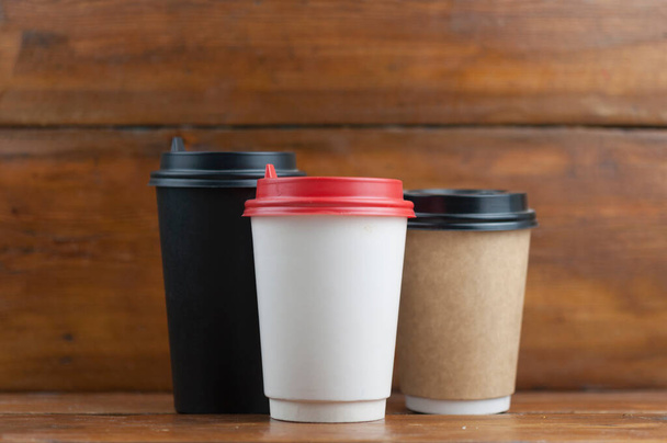 trois tasse à café jetable sur fond en bois avec espace de copie - Photo, image