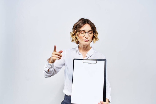 Business woman with a folder of white documents in her hand on a light background And hairstyle glasses model - Photo, Image