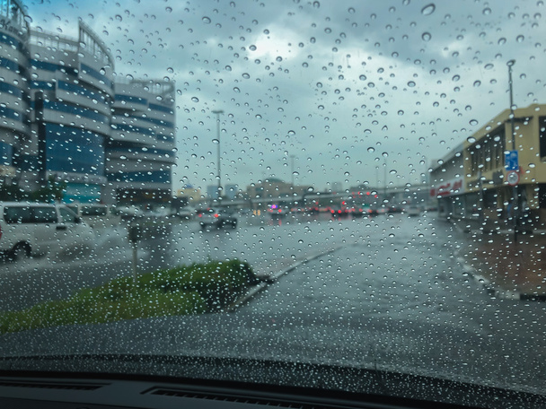 Ciemne chmury nadciągają i ulewne deszcze zalewają drogi Dubaju, utrudniając kierowcom i kierowcom poruszanie się. - Zdjęcie, obraz