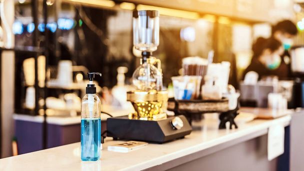 Blauer Alkohol Gelflasche für die Reinigung der Hände, um die Ausbreitung des Corona-Virus (Covid-19) zu verhindern, Platzieren Sie den Eingangsservice für Kunden im Café. Gesundheitskonzept. Neuer normaler Lebensstil. - Foto, Bild
