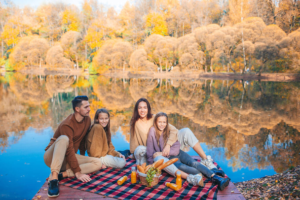 Hermosa familia en otoño cálido día cerca del lago - Foto, imagen
