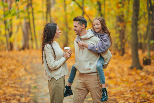Portrait of happy family of three in autumn day - 写真・画像
