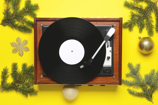 Музыкальный проигрыватель и рождественский декор на цветном фоне - Фото, изображение