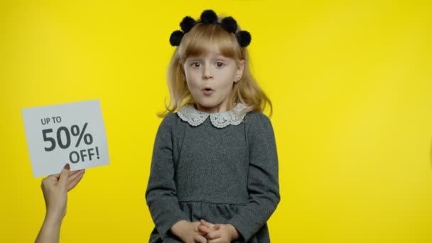 Inscription advertising discount Up To 50 Percent Off appears next to smiling kid pupil girl - Footage, Video