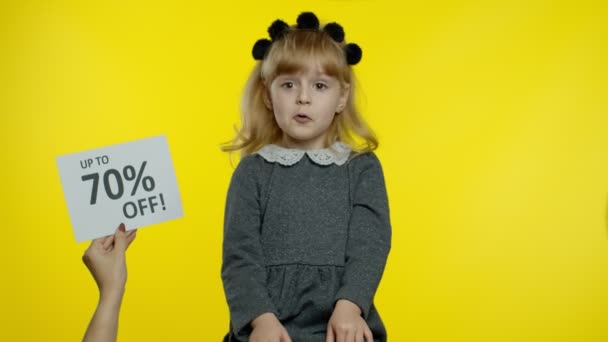 Inscription Up To 70 Percent Off appears next to smiling child girl. Preschooler kid celebrating - Footage, Video