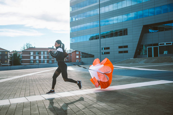 Female urban runner training in the city center. Beautiful woman doing sport in the early morning - Fotoğraf, Görsel