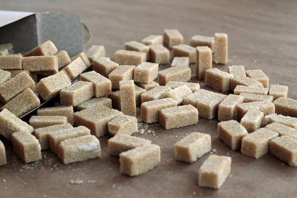 Brown sugar cubes out of the box on the brown kraft paper - Foto, Imagen
