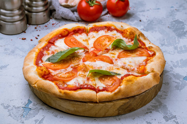 Margherita méditerranéenne pizza savoureuse aux tomates rouges et feuilles de basilic vert  - Photo, image