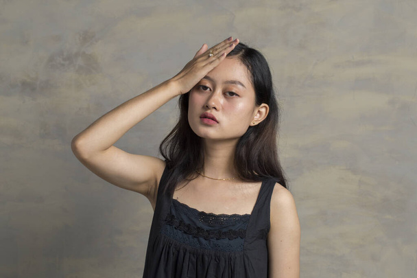 頭痛やうつ病を持っている額に触れる悲しい疲れ若いアジアの女性 - 写真・画像