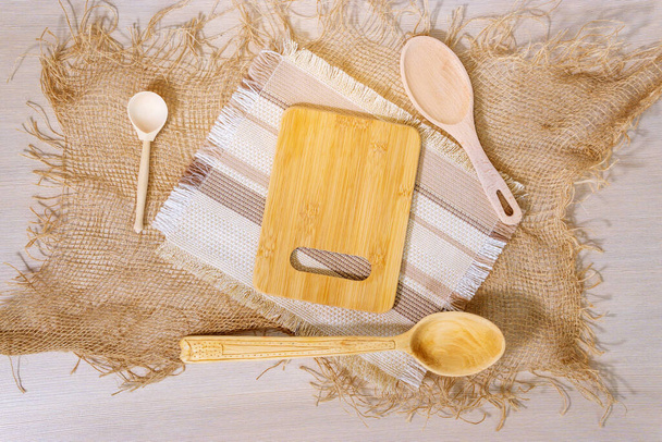 sfondo di legno chiaro, posate di legno - un cucchiaio di legno e taglieri. vista dall'alto piatto lay - Foto, immagini