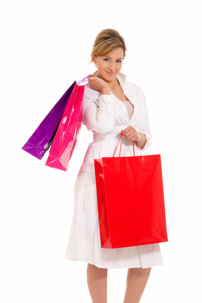 junge Frau mit Einkaufstaschen steht isoliert auf weißem Hintergrund - Foto, Bild