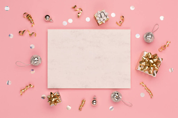 Christmas holiday greeting card template. Gold and silver decorations, festive gifts, mirror disco balls on pink background. Xmas, winter, new year concept. Flat lay, top view, copy space. - Foto, imagen