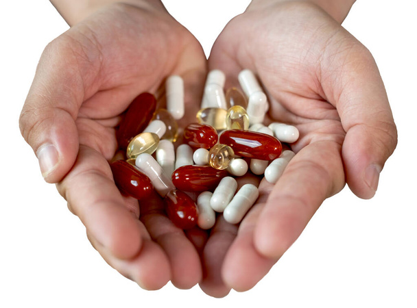 Sok tablettát és vitamint az orvos kezében izolálni fehér háttér. - Fotó, kép