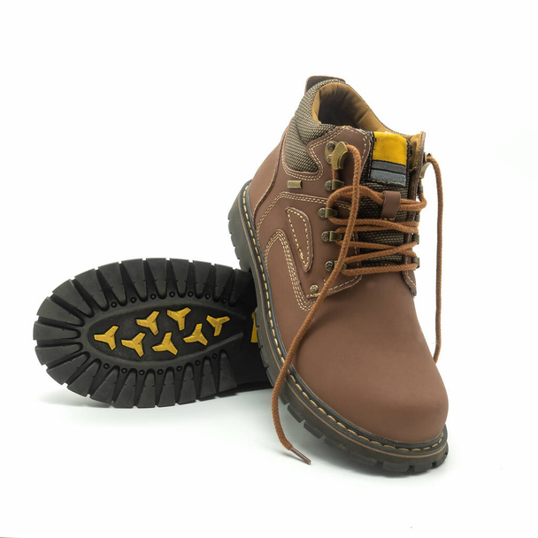 Men's winter youth boots with laces. Brown leather, metal hardware, thick grooved sole. Decorated with white stitching. Isolated over white background. - Photo, Image