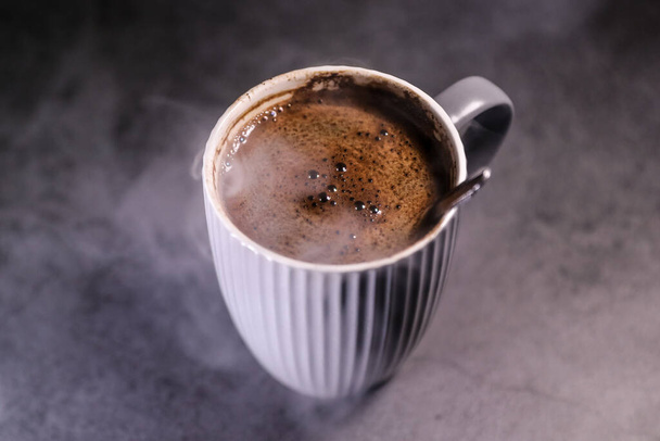 Tazza di caffè nero fresco al vapore su un tavolo scuro. espresso del mattino. - Foto, immagini