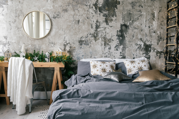 Sypialnia w stylu Loft w nowoczesnym apartamencie designerskim z rustykalnym kserem ściany, wygodne łóżko, lustro nad drewnianym stołem i zimą domu wystrój - Zdjęcie, obraz