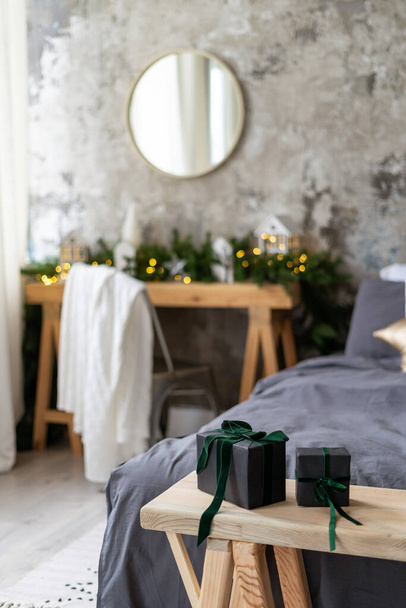 Kış tatilini evde kutlama kavramı. Konforlu yatak odasındaki ahşap bankta bulunan ve iç tasarımı olan iki kutunun dikey görüntüsü - Fotoğraf, Görsel